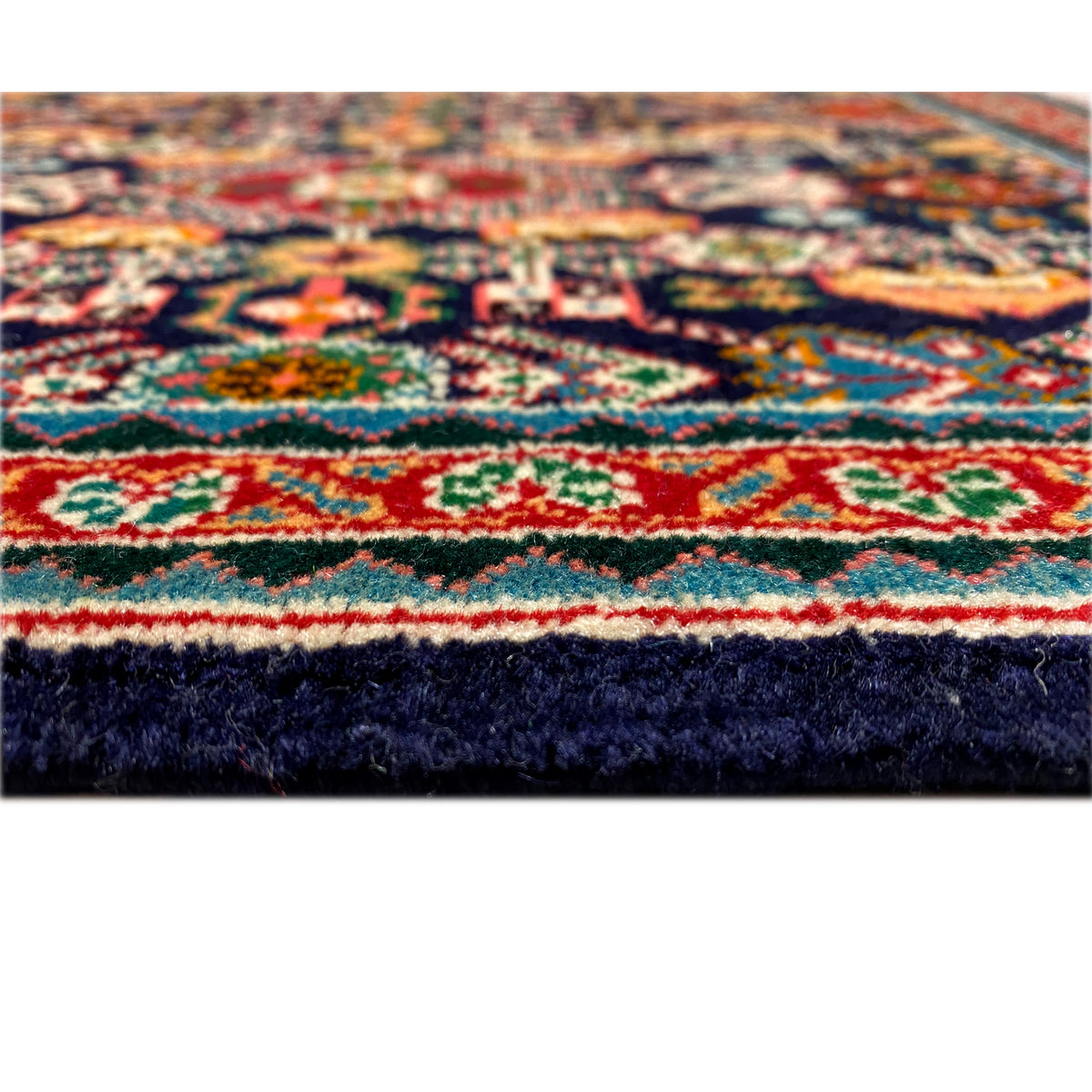 Rug 61x60 cm, detailed view of the edge: multicolored border with dark pile.