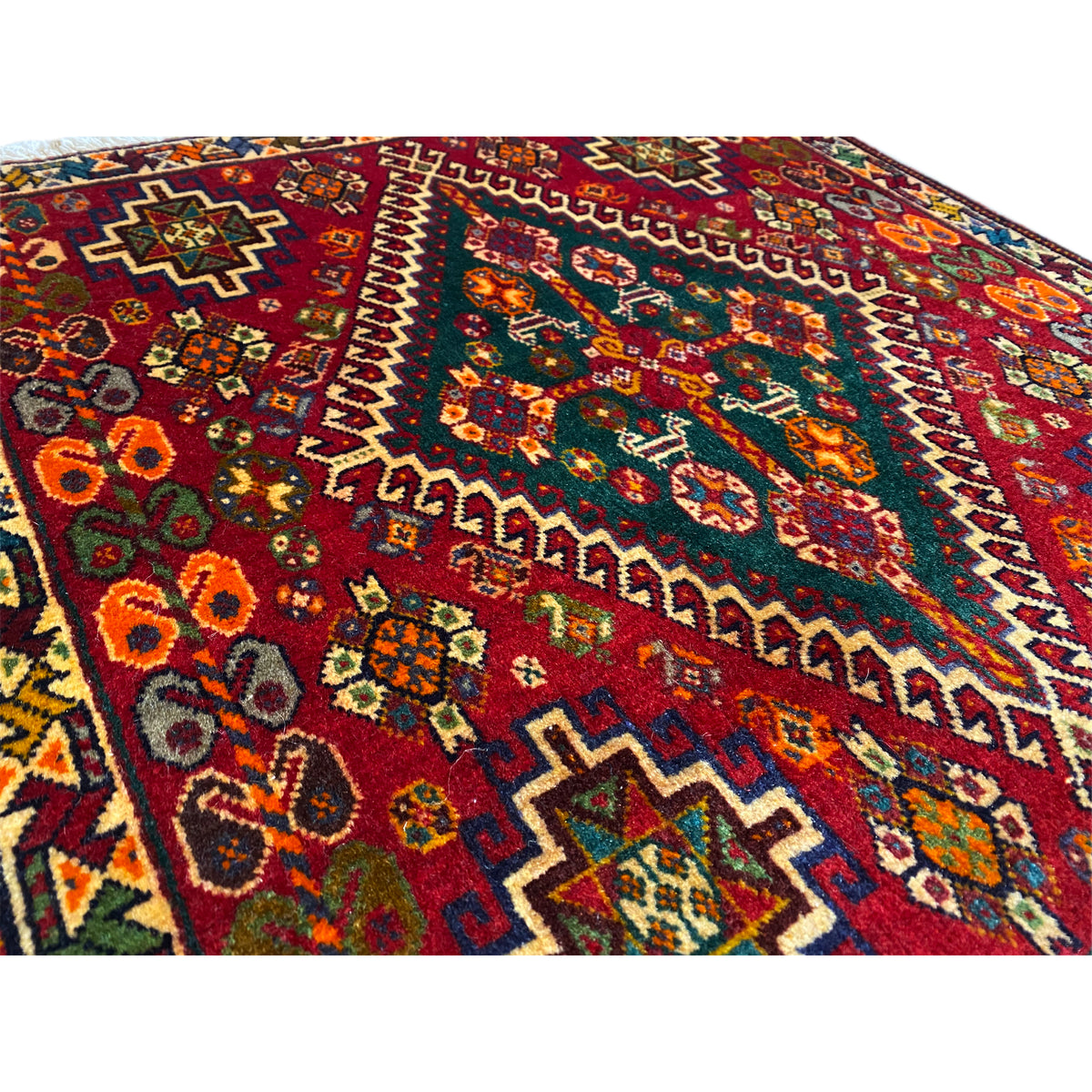 Close-up of the carpet pattern: burgundy background with colorful ornaments