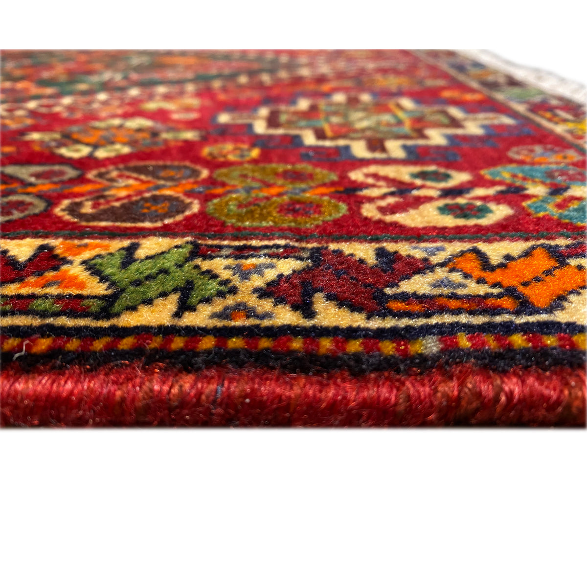 Detail at the edge: multicolored rug with thick red fringed trim