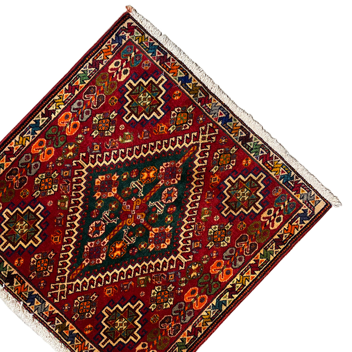 Triangular perspective: burgundy-red rug with geometric patterns and white fringes