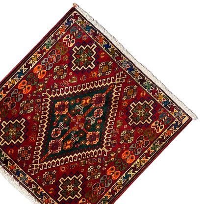 Triangular perspective: burgundy-red rug with geometric patterns and white fringes