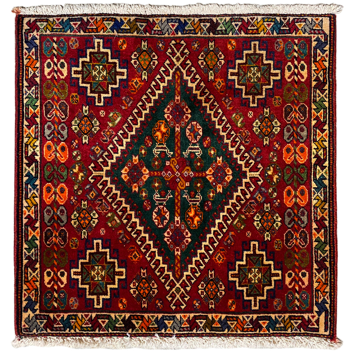 Oriental rug with a burgundy background and multicolored pattern, finished with fringes