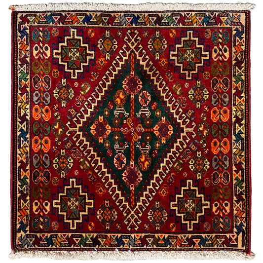 Oriental rug with a burgundy background and multicolored pattern, finished with fringes