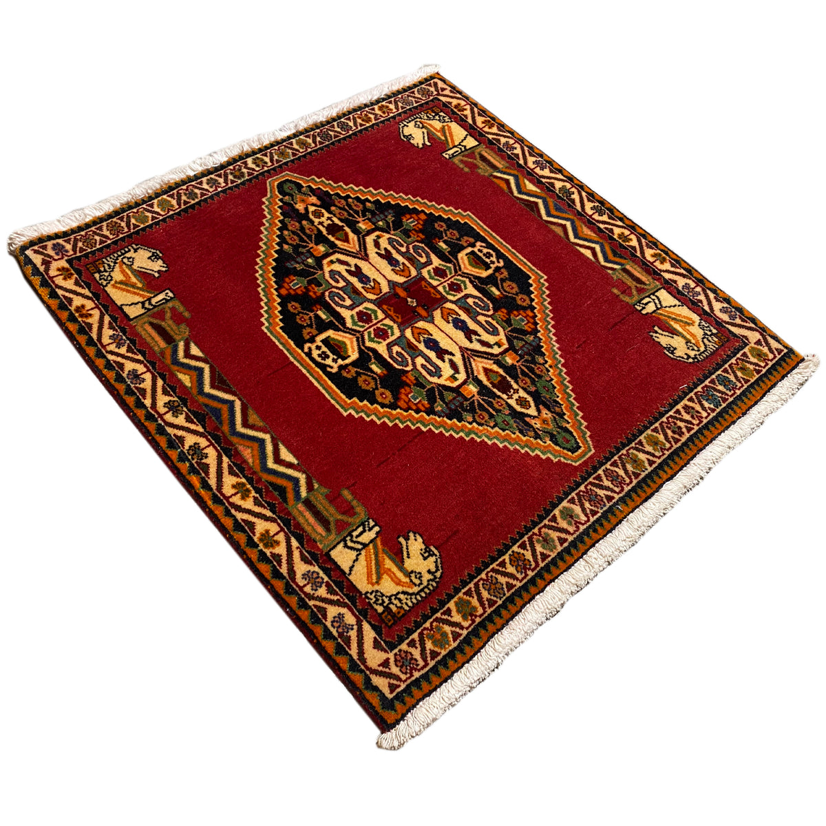 Rug in diagonal view: red field with an ornamental medallion and colorful border