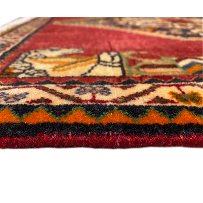 Detail at the edge: deep red pile, multicolored ornaments, and a textured edge with fringes
