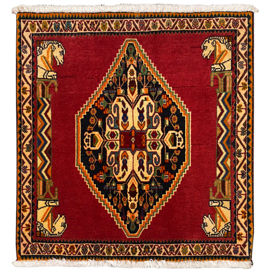 Rug with a red ground, central medallion, geometric border, and decorative fringe