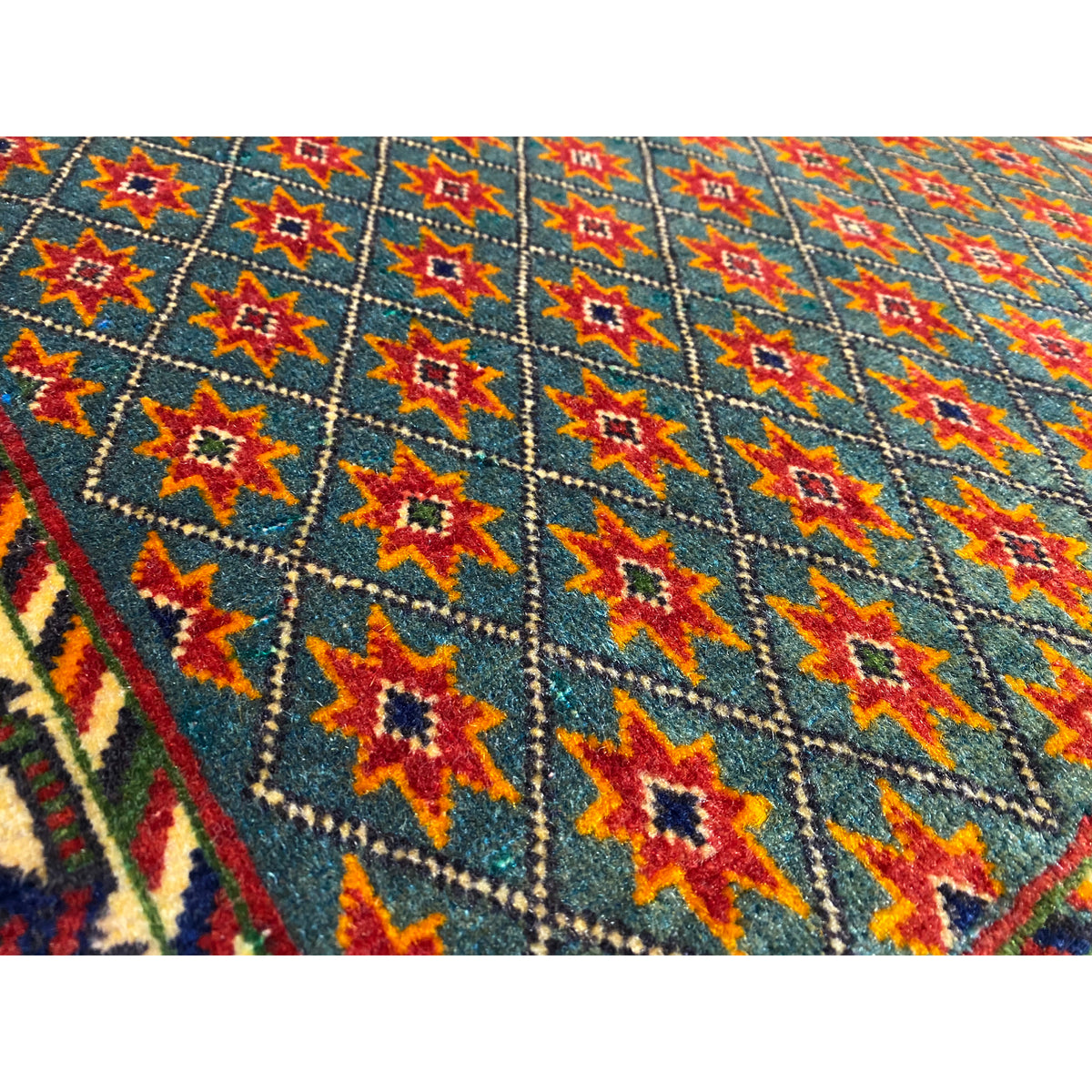 Close-up: blue carpet fabric with colorful stars and diamond patterns