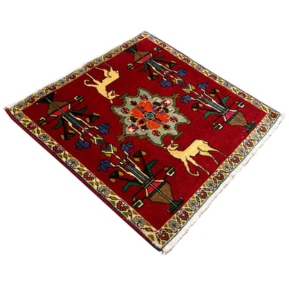 Poshti rug (67x64 cm), angled: red ornamental design with animal motifs and a border.