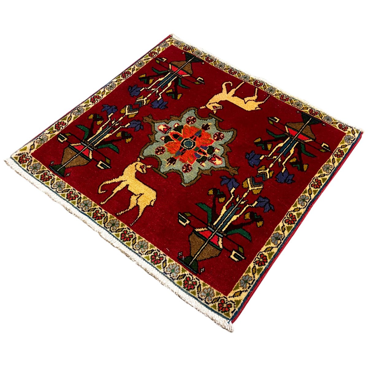 Poshti carpet (67x64 cm) at an angle: red pattern with floral elements and multicolored border.