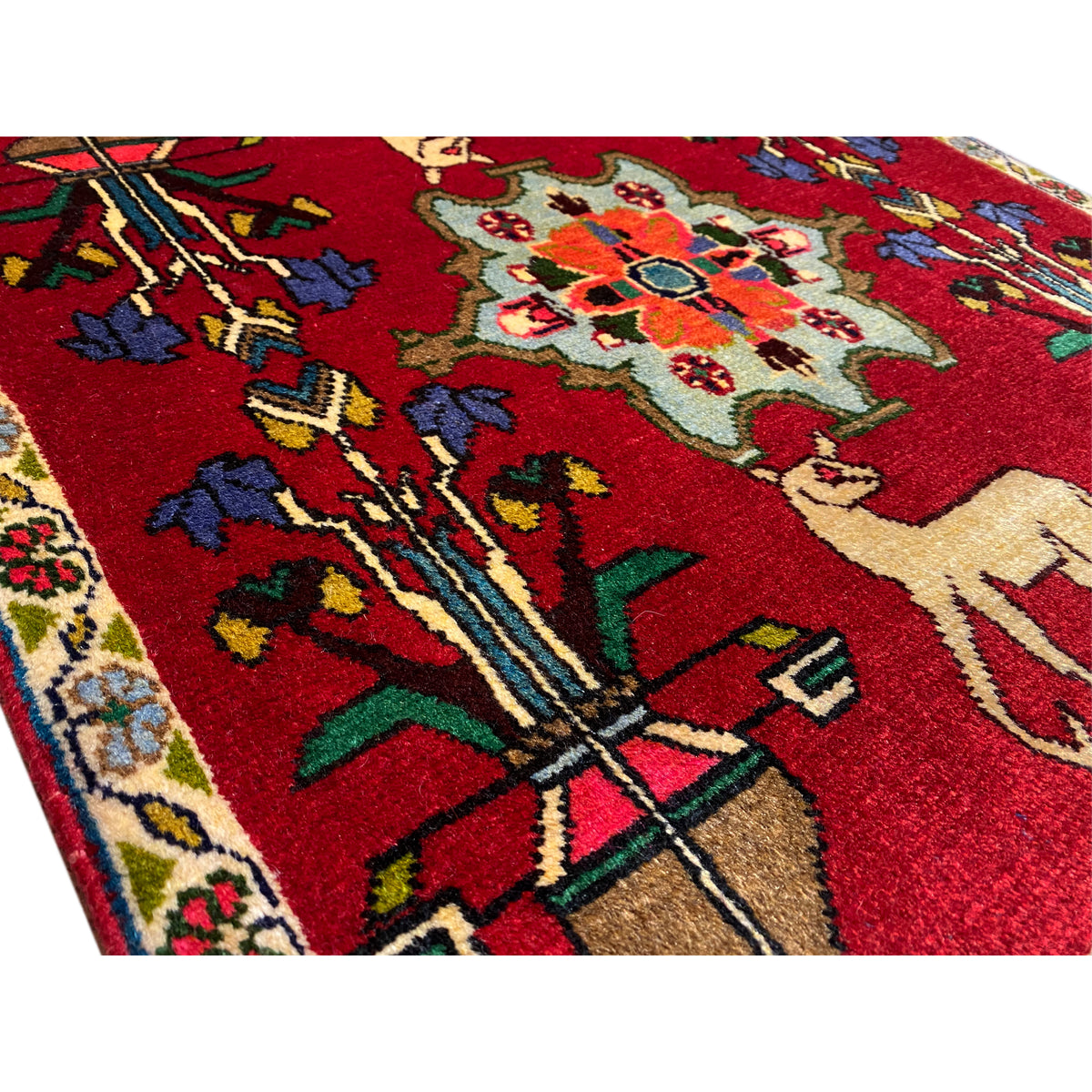 Poshti rug (67x64 cm) close-up: red design with ornaments and an animal figure.