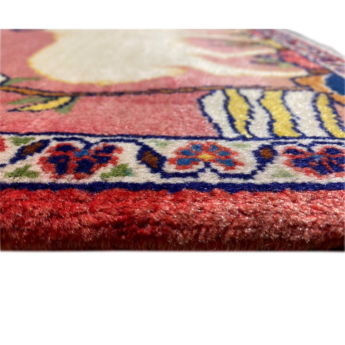 Carpet detail with fringes and a blue-red border pattern along the lower edge
