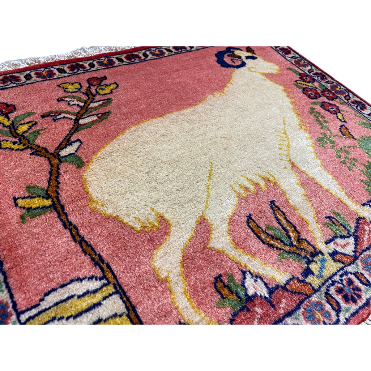 Close-up of a rug: soft pile with an animal motif, red-beige color gradient, colorful ornaments
