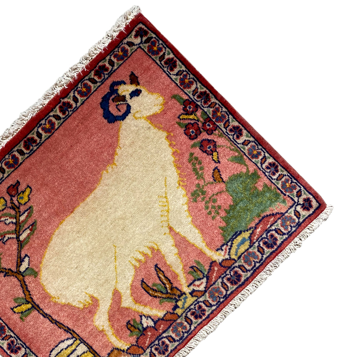 Rug in angled view: animal motif with flowers in a frame, red, beige, fringe at the corner