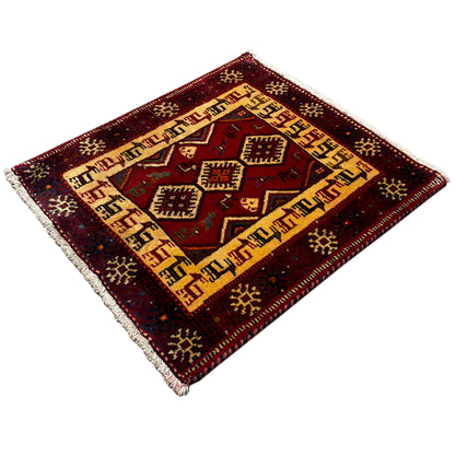 Dark red rug with a beige border, central diamonds, and short fringes