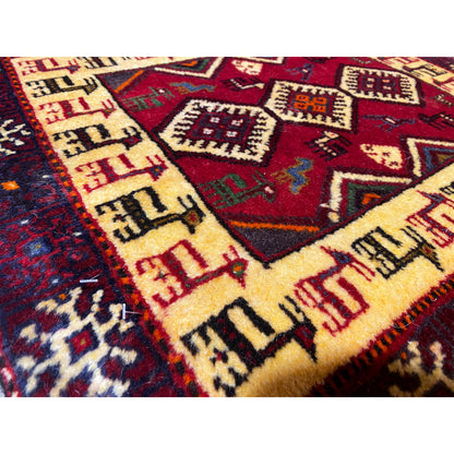 Close-up: carpet pattern with diamonds, ornaments, and vibrant accents on dark red