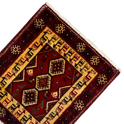 Carpet corner with a beige border, dark red background, and geometric diamonds in the center