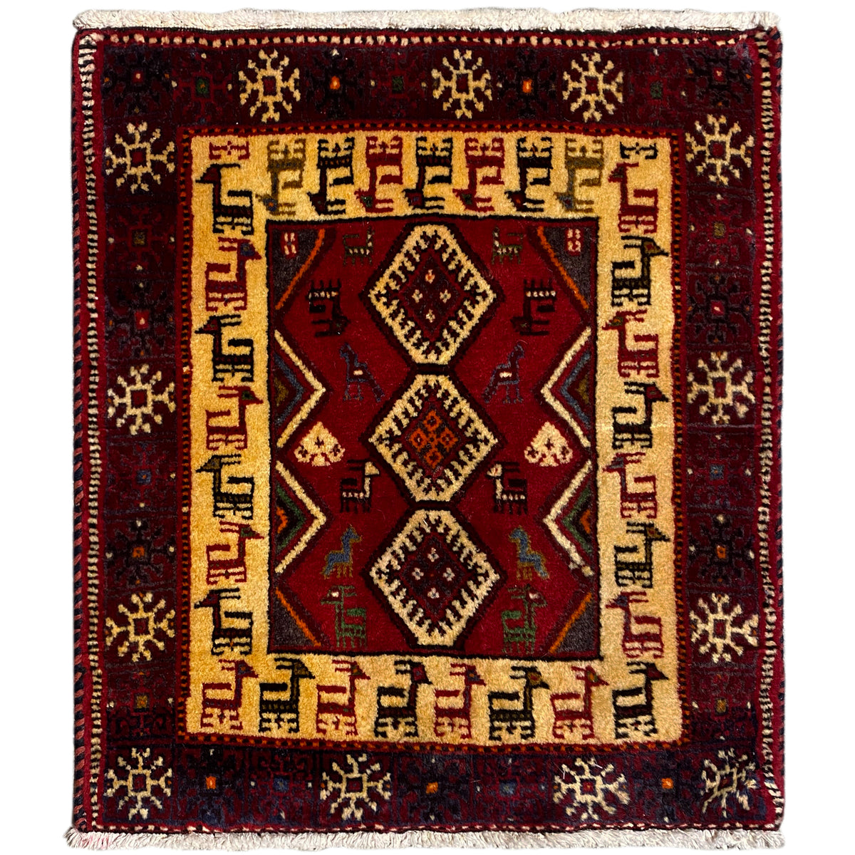 Square dark red rug with a beige patterned border and central diamonds