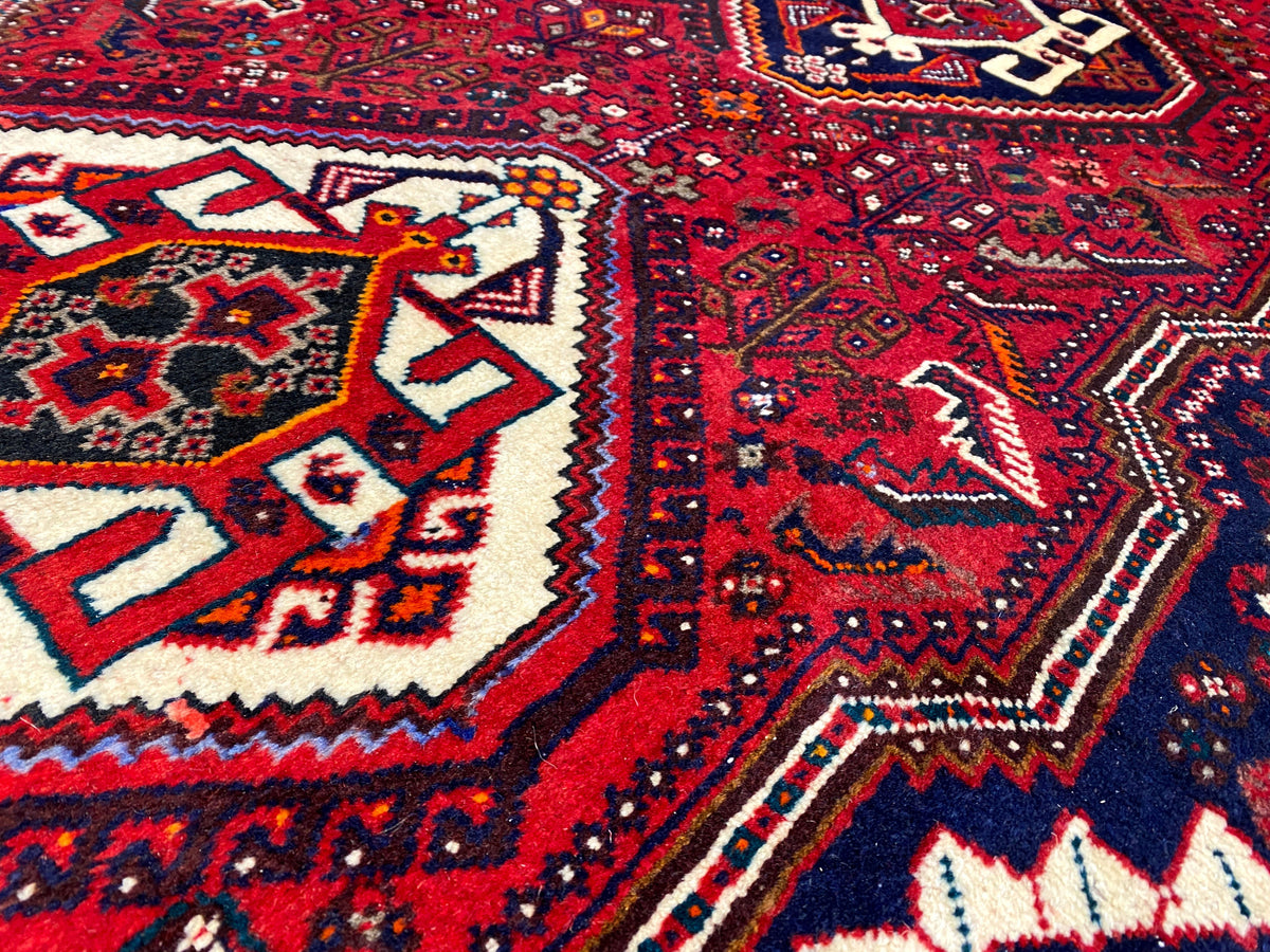 Detailed view of the Oriental rug runner: red pattern, white shapes, dark blue background