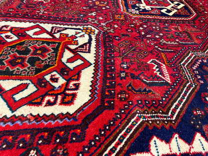 Detailed view of the Oriental rug runner: red pattern, white shapes, dark blue background