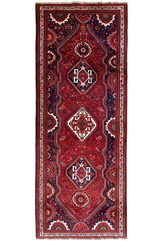 Oriental rug runner (297x115 cm) with a red ground, central diamonds, and dark blue borders