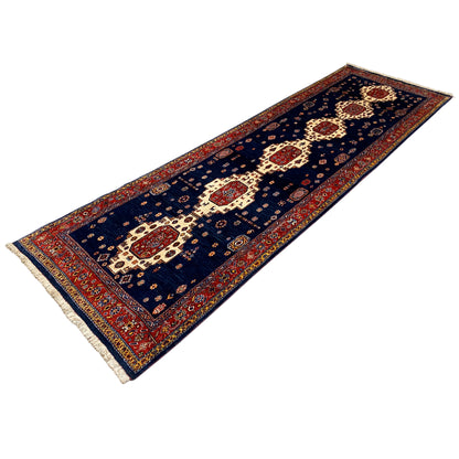 Dark blue runner rug with central red medallions and beige fringe
