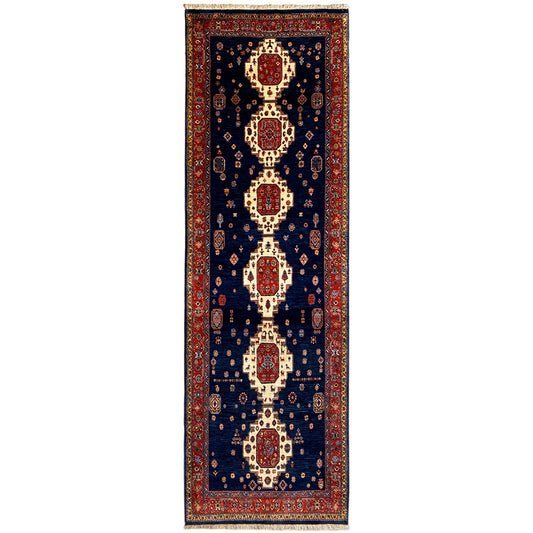 Runner rug with a dark blue background and a red and cream medallion pattern