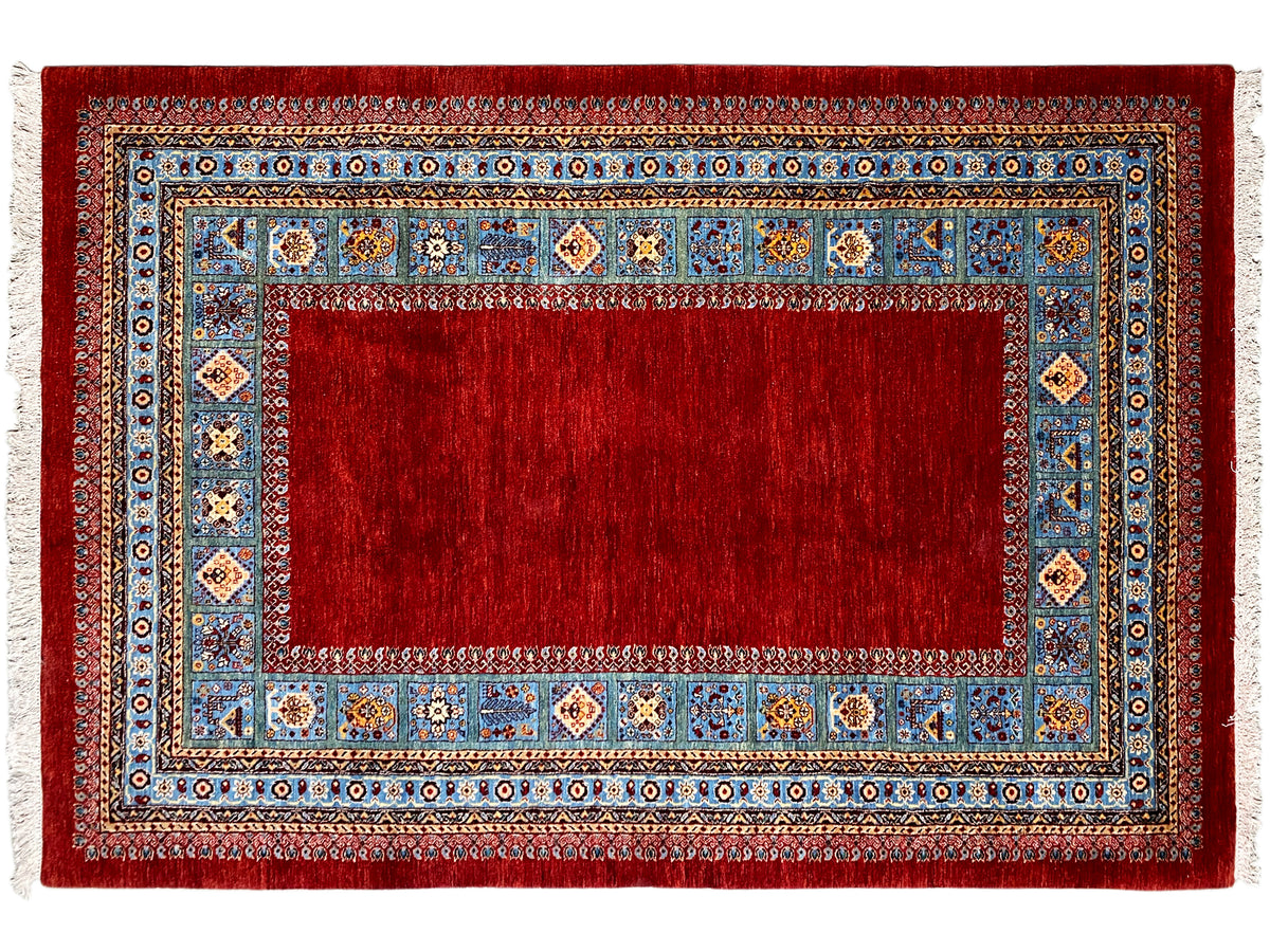 Roter Teppich mit blauem Rahmen und mehrfarbigen Ornamenten, flach liegend.