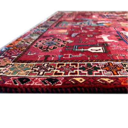 Close-up of a Qashqai rug: red pattern, colorful ornaments, and textured pile