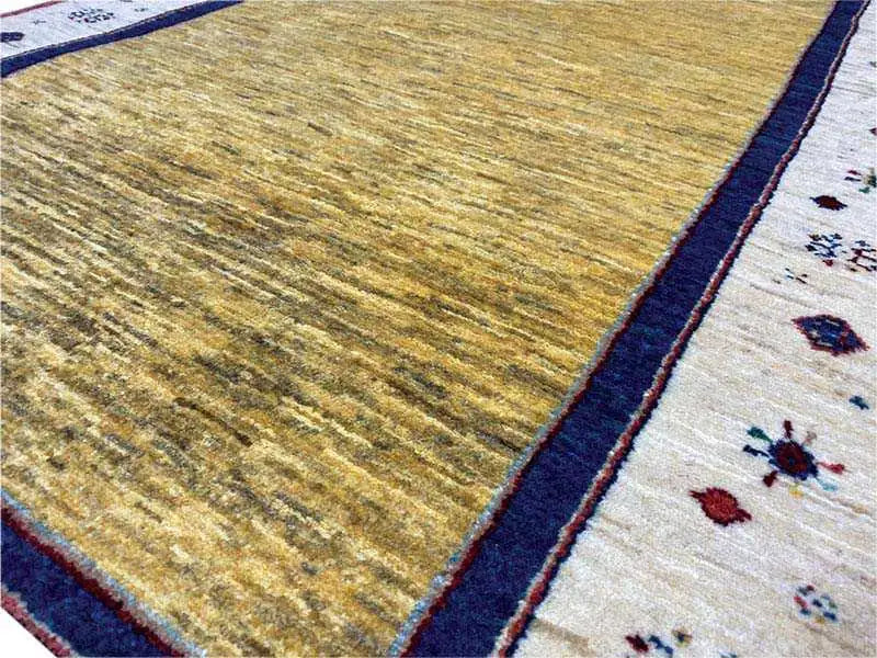 Carpet detail: yellow pile area with a blue border and white patterned area