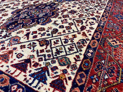 Close-up of the Qashqai carpet pattern: cream-colored field with blue-red ornaments