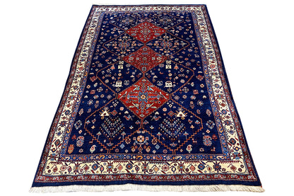 Blue oriental rug with a central red medallion and ornamental details, with fringes.