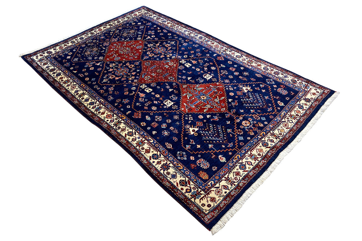 Blue Oriental rug with a red medallion, geometric ornamental pattern, and fringe.