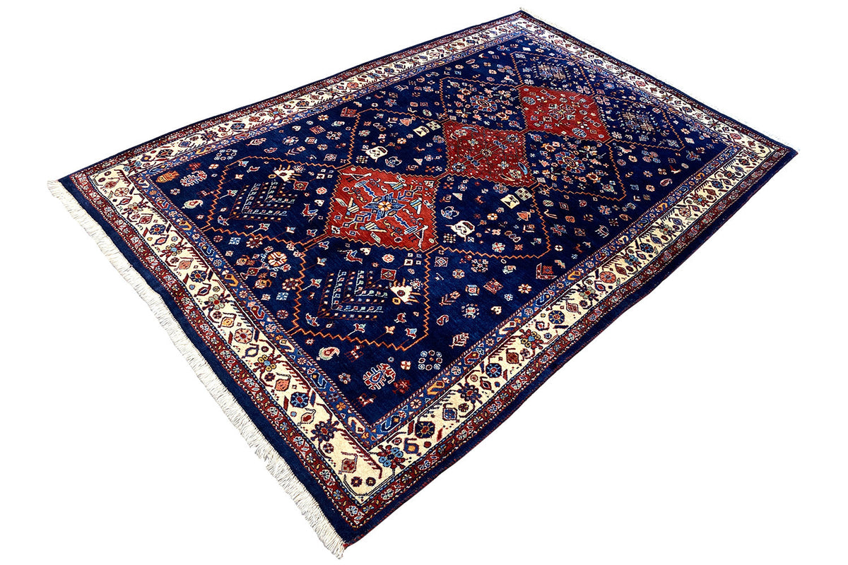 Blue oriental rug with a red center, delicate ornamental border, and fringes.