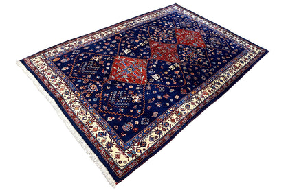Blue oriental rug with a red center, delicate ornamental border, and fringes.