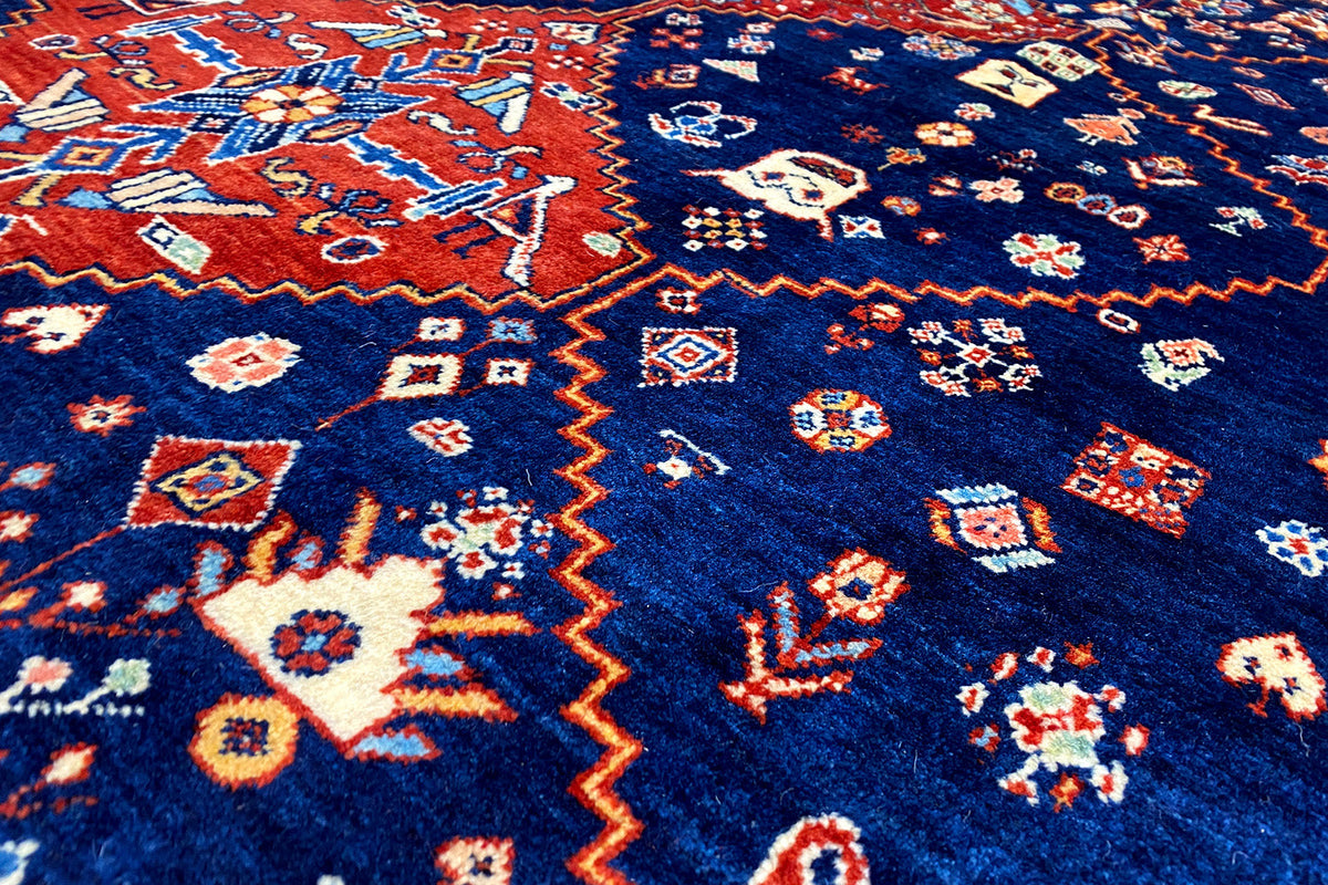 Close-up: blue carpet with colorful geometric patterns in the pile.