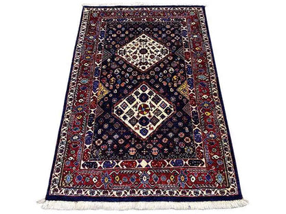 Carpet with dark blue, red border, ornamental medallions, and fringe