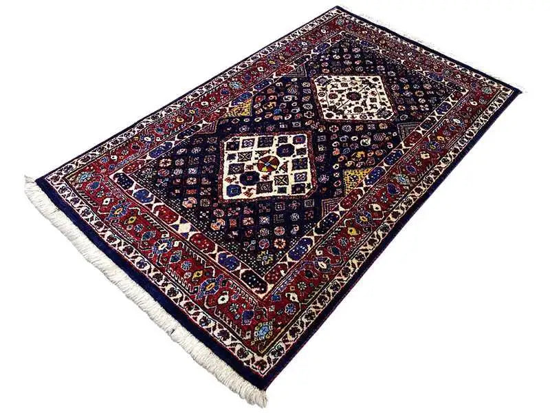 Dark blue rug with a red border, square ornaments, and fringes