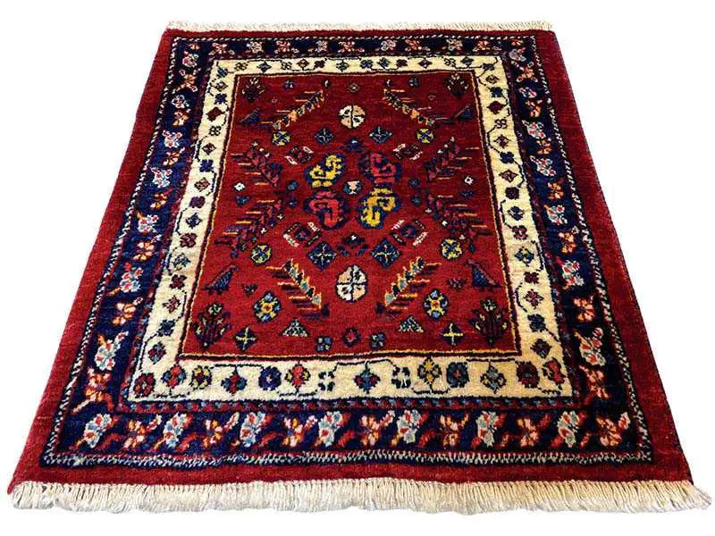Red oriental rug with a blue border, beige elements, and fringes