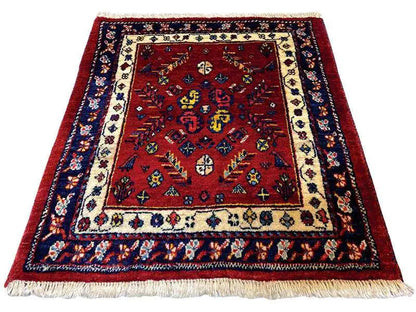 Red oriental rug with a blue border, beige elements, and fringes