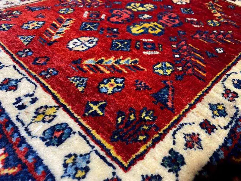 Close-up of the carpet pattern: red with colorful ornaments in blue and beige