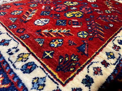Close-up of the carpet pattern: red with colorful ornaments in blue and beige