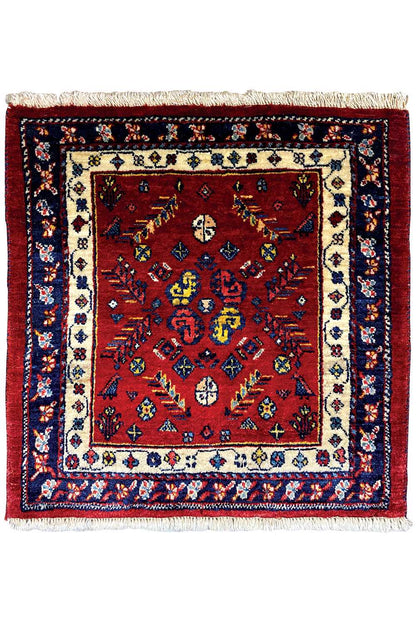 Square red Oriental rug with a blue border, beige central medallion, and fringes