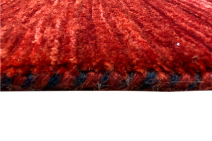 Close-up of the red carpet pile with fringe along the bottom edge