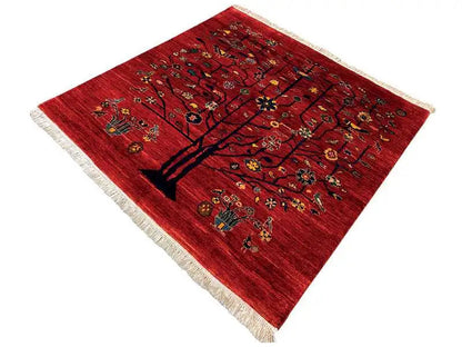 Red carpet with a tree motif and colorful patterns, seemingly square perspective, fringe