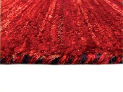 Close-up of red carpet pile with fine patterned threads and dark edge fringes