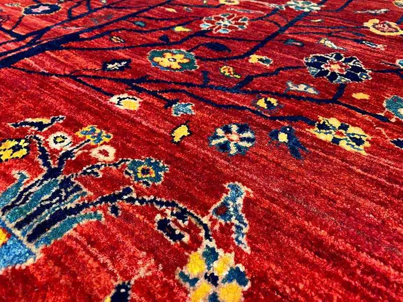 Close-up: red carpet with blue-yellow-red ornaments and a fine woven pattern