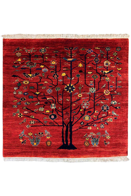 Red Oriental rug with a central tree motif, colorful designs, and fringes on all sides