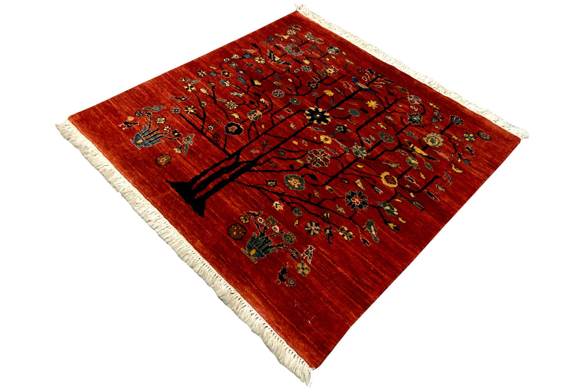 Qashqai rug with a tree motif on a red pile, with fringes