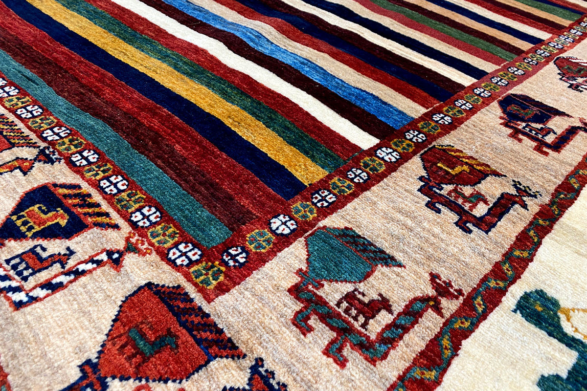 Detail view: multicolored stripes and animal motifs along the edge of the rug
