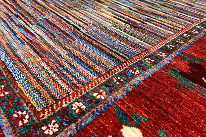 Close-up: multicolored striped carpet pattern with a red border area and flowers